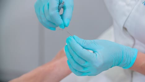 masajista y esteticista está utilizando una herramienta especial para la terapia de los pies de su cliente