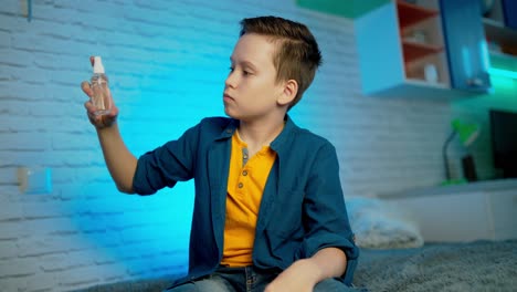 boy using hand sanitizer alcohol spray rub for hands hygiene in home for preventive coronavirus spread epidemic prevention.