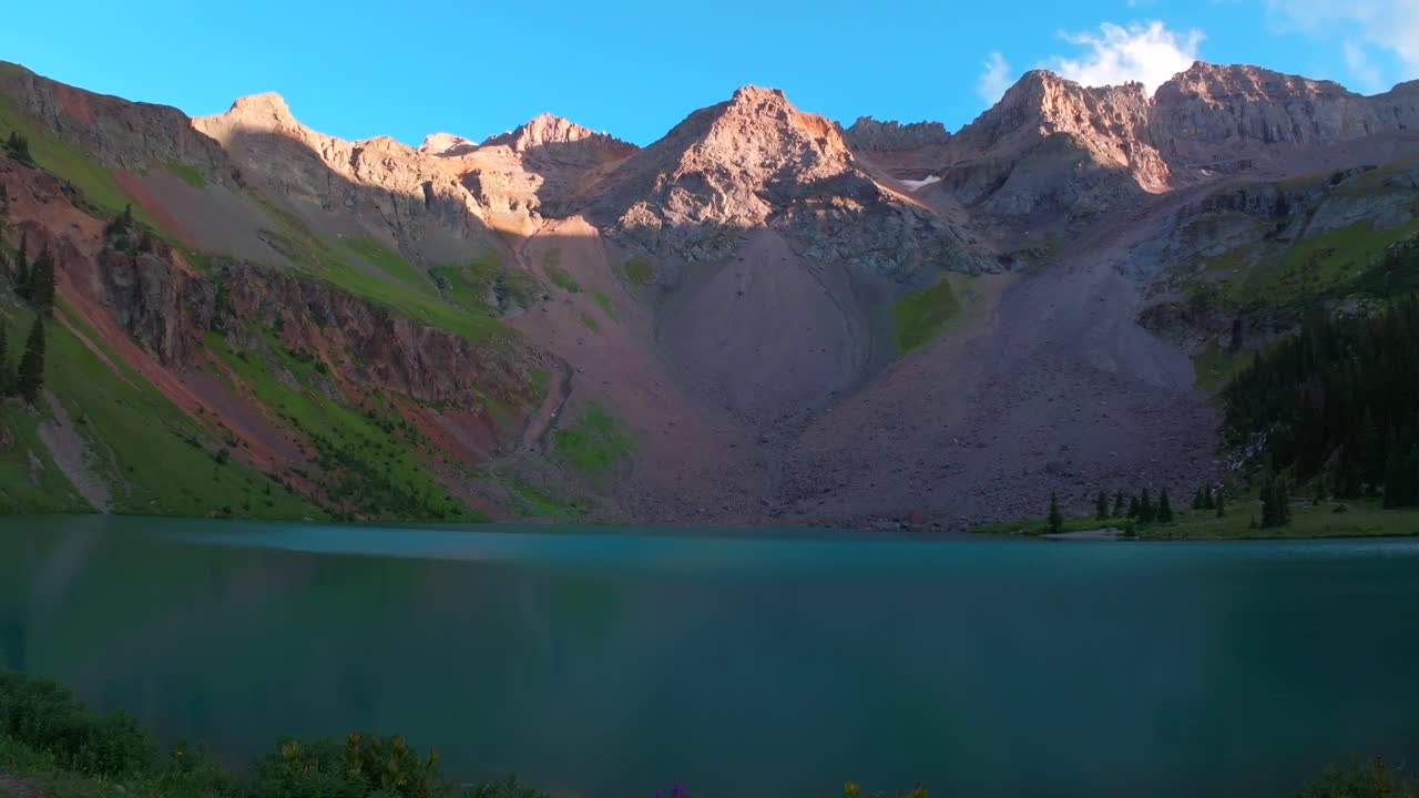 Sunset hiking trail wildflowers Lower Blue Lakes Mount Sneffels Wilderness drone forward pan up summer Ridgway Telluride Colorado Rocky Mountains Uncompahgre National Forest San Juan Dallas Range