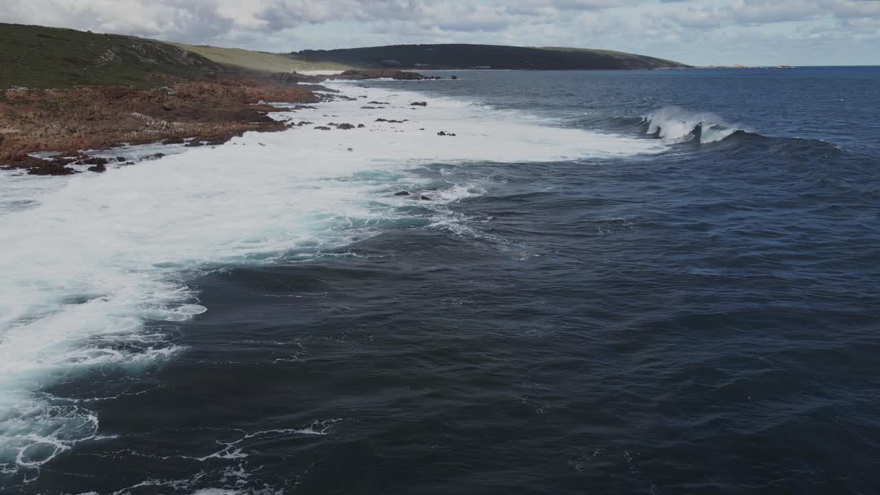 Aerial flight of waves rolling in on the coast