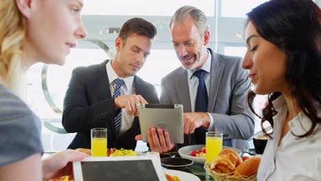 four smiling people watching their tablet