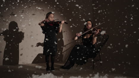 mother and daughter playing violin in a winter studio