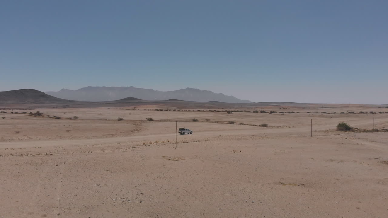 toma aérea lateral del vehículo que viaja por una carretera desierta vacía