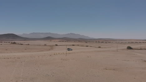 toma aérea lateral del vehículo que viaja por una carretera desierta vacía