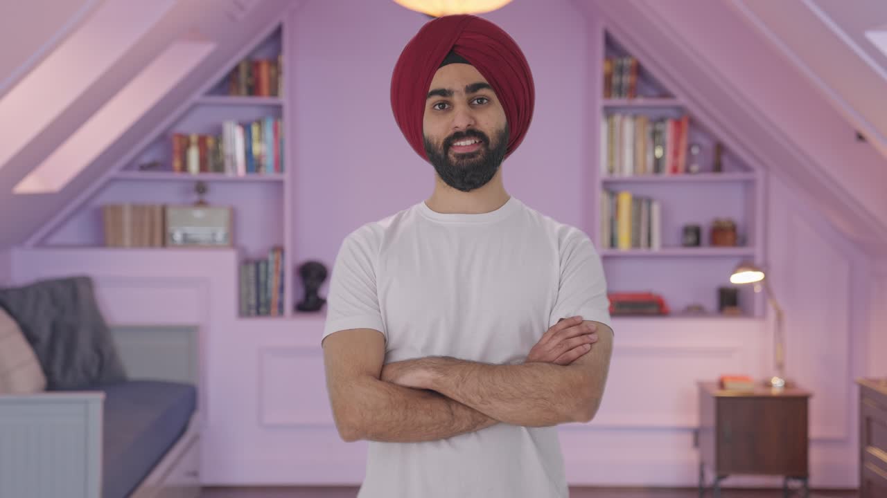 hombre indio sikh feliz de pie con las manos cruzadas