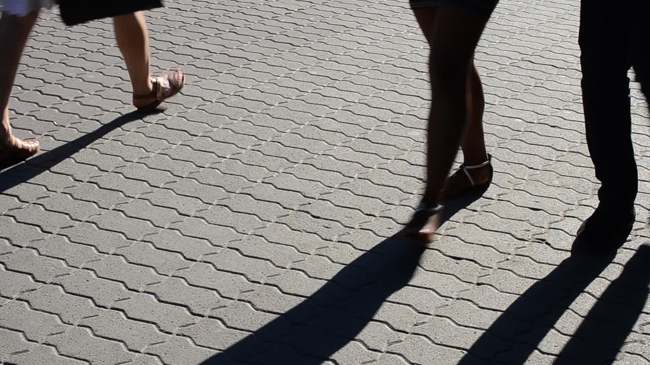 Light and shade, reflection of people in beams of the setting sun. Movement of group of people