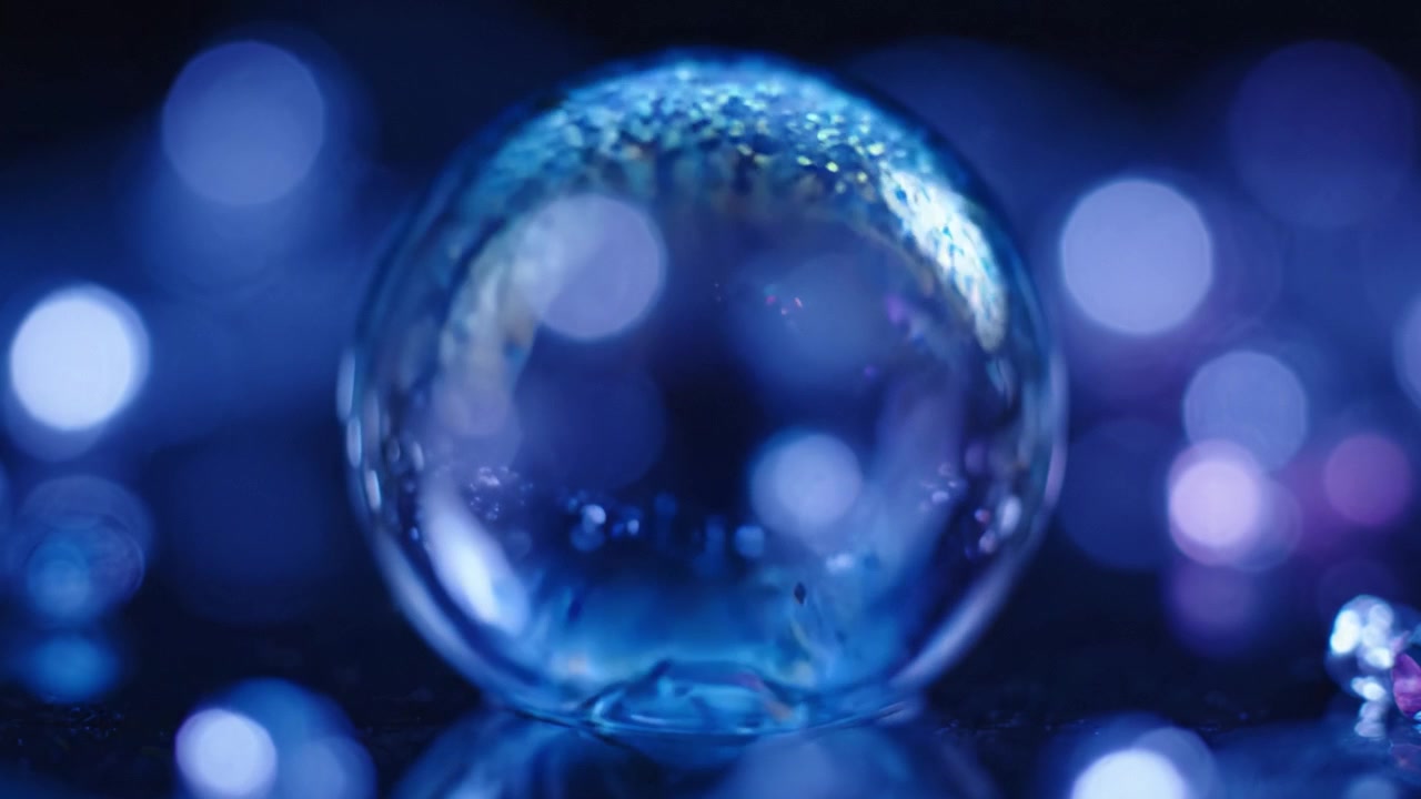 En fascinerende krystalkugle glimter med refleksioner og levende bokeh-effekter, der viser en fortryllende udstilling af farver og lys under dens delikate overflade.