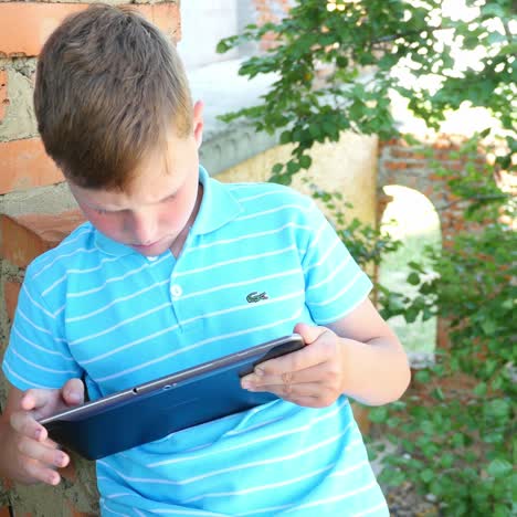 caucasian boy in the park with laptop