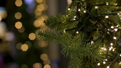 vista del árbol de navidad con luces led y luces fuera de foco en el fondo