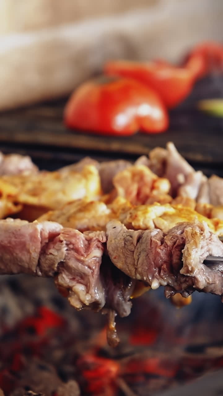 Barbeque on a stove. Meat and vegetables being grilled. Juicy meat and vegetables on coals. Kebab on metal skewers barbecue. Vertical video