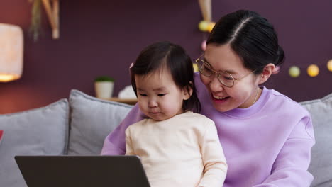 거실 에서 아기 와 함께 있는 아시아인 어머니