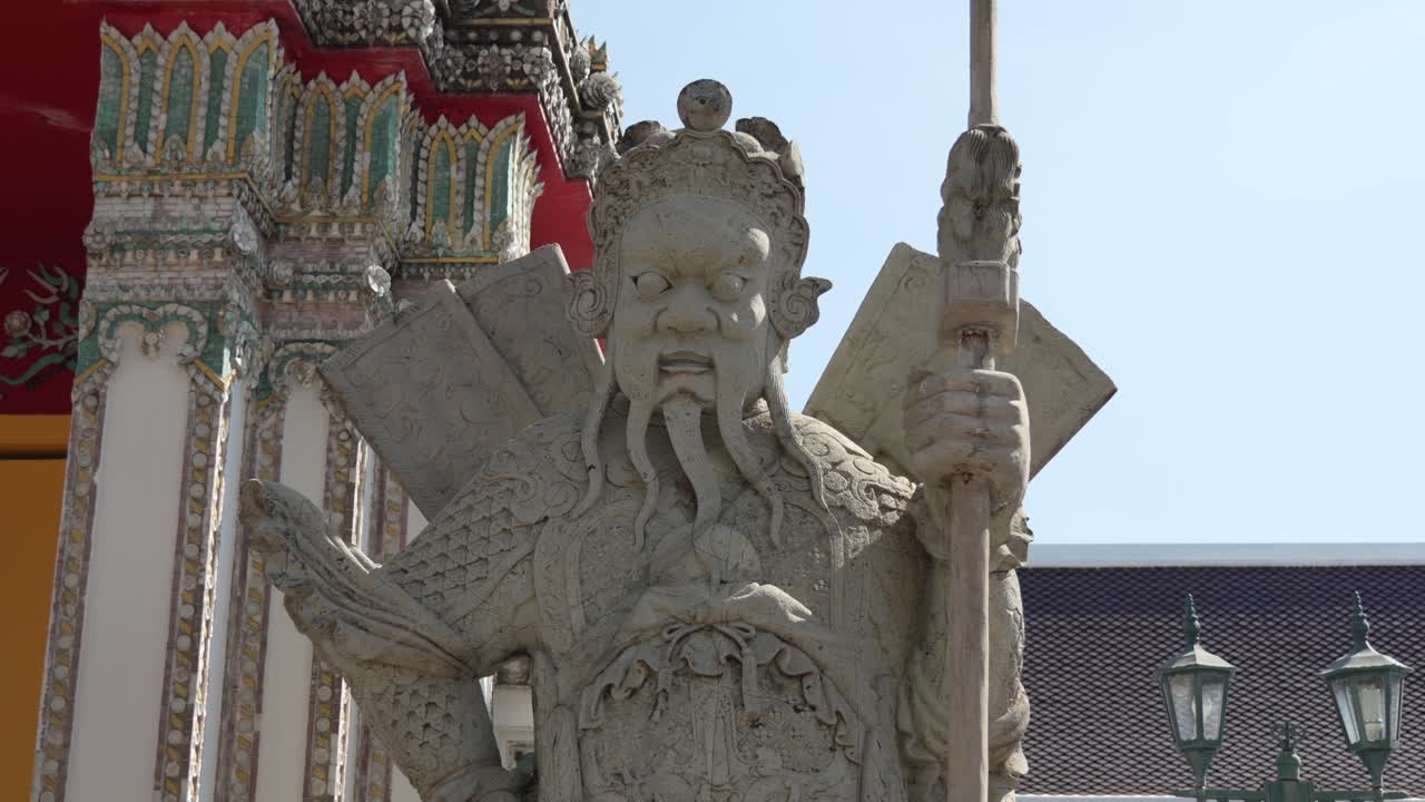 The ancient warrior statue guarding the entrance of Wat Pho temple in Bangkok, Thailand, symbolizes strength, protection, and traditional Thai craftsmanship