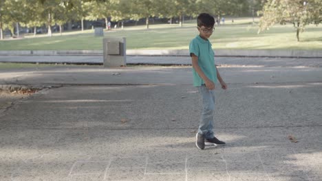 side view of kids playing hopscotch on asphalt