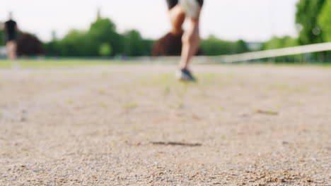 low section of male runner running from camera on a track