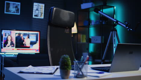 laptop, mini house plants and headphones on table in empty room