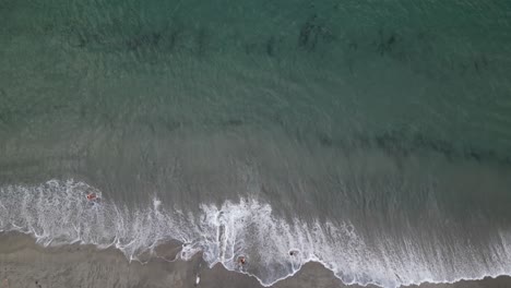 birds eye aerial view of ocean waves breaking on sandy beach in twilight, boca raton, florida usa, top down drone shot