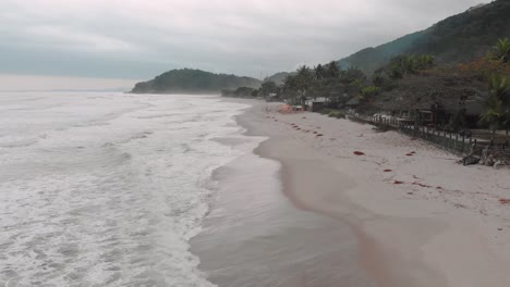 imágenes de drones laterales de la playa, montaña frente al mar, día nublado, olas, paisaje de juquehy, ubatuba, costa norte de são paulo, brasil