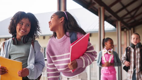 group of diverse students walking in school corridor
