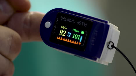 pulse oximeter working on a male's hand in the medical center before covid-19 vaccination