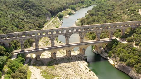 ponte do aqueduto pont du gard construída pelos romanos no primeiro século, sul da frança, cruzando o rio gardon, panorâmica aérea à esquerda