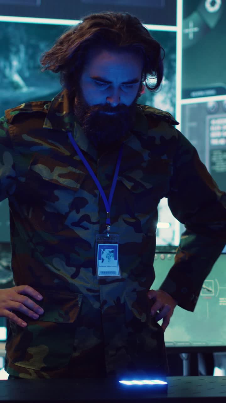 Military Man Interacting with High-Tech Device in Control Room