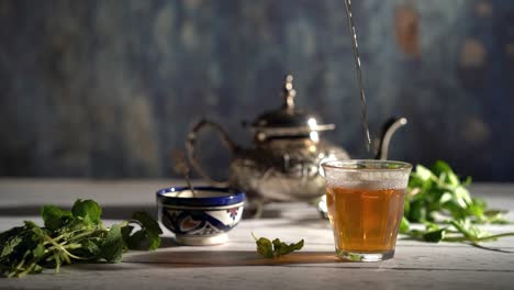 cinemagraph of tea pouring into a glass with moroccan tea set and mint