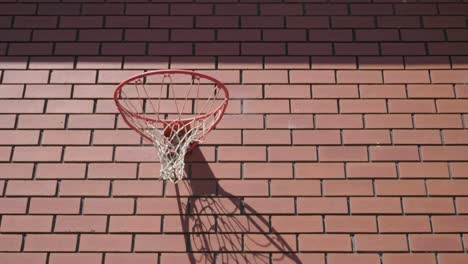 front shot of basketball going swish into net on red brick wall background to score goal