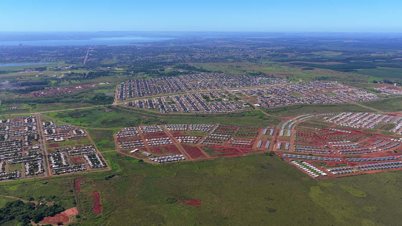 Wide aerial view of Itaembé Guazú residential development with Posadas city, Paraná River and Paraguay in the background, Argentina