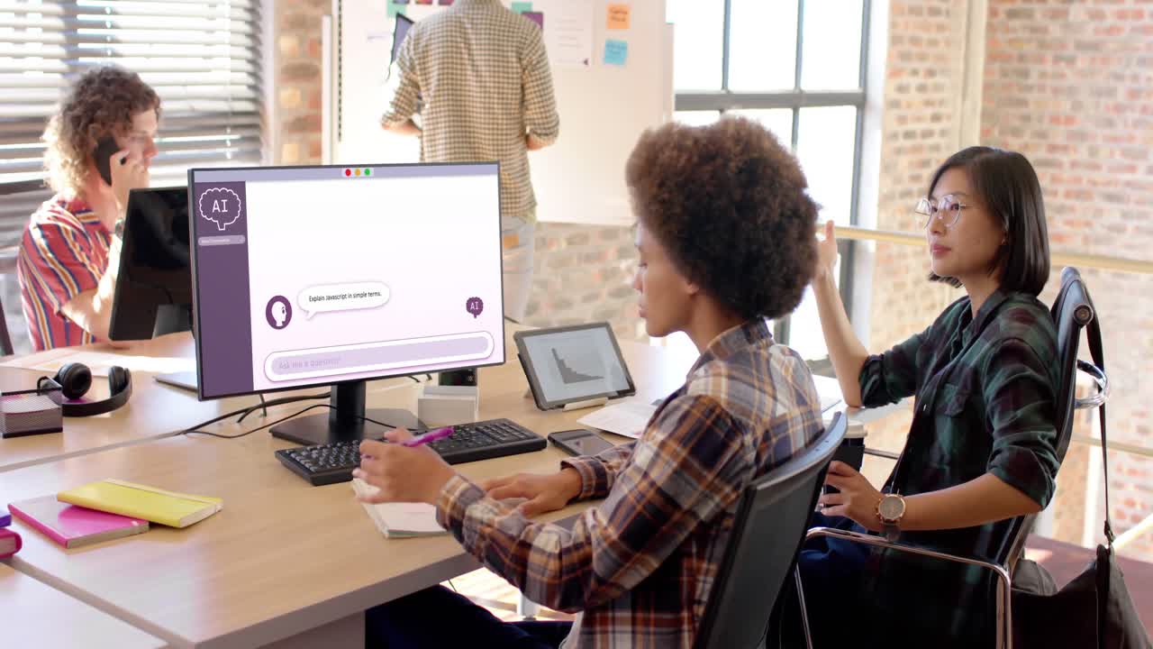 Diverse business people talking and using computer with digital chat on screen in office