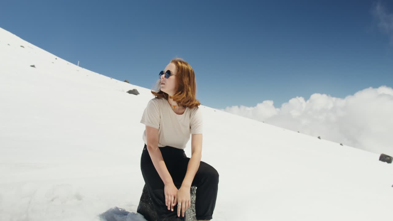 Teenager Sitting on a Snow-Covered Mountain