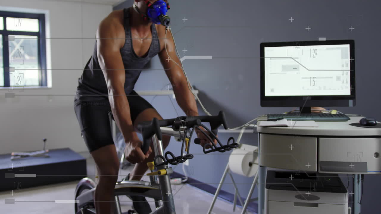 Cycling on stationary bike, athlete wearing mask with animation data on screen