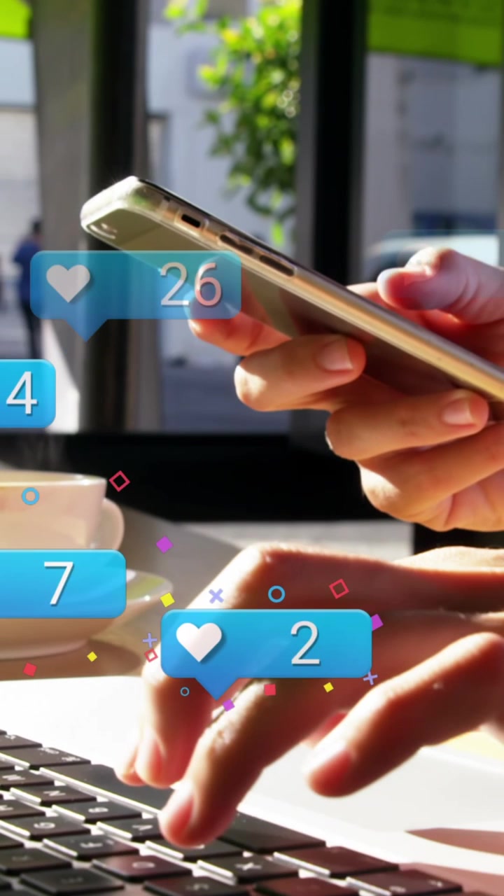 Animation of social media icons falling over person using laptop