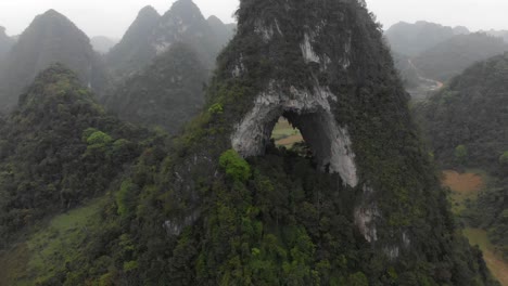 Flying-backwards-at-Angel-eye-mountain-Cao-bang-Vietnam,-aerial