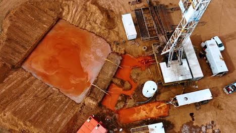descending over the site for production oil or gas. tall derrick producing water flowing into the square pool.