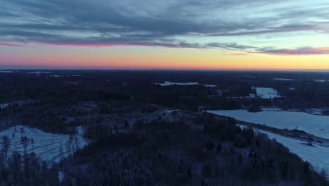 Cold-winter-woodlands-and-bright-colorful-sunset-sky,-aerial-view