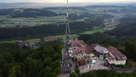 aerial establishing shot of a communications tower at the top of a hill in zurich