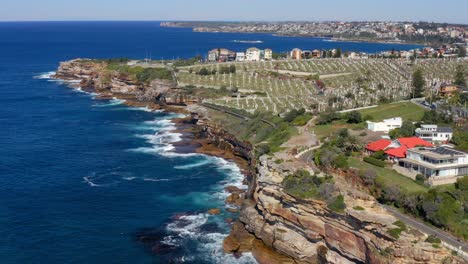 Olas-Rompiendo-En-Acantilados-Rocosos-Con-El-Cementerio-Waverley-En-Bronte,-Sydney,-Nsw,-Australia