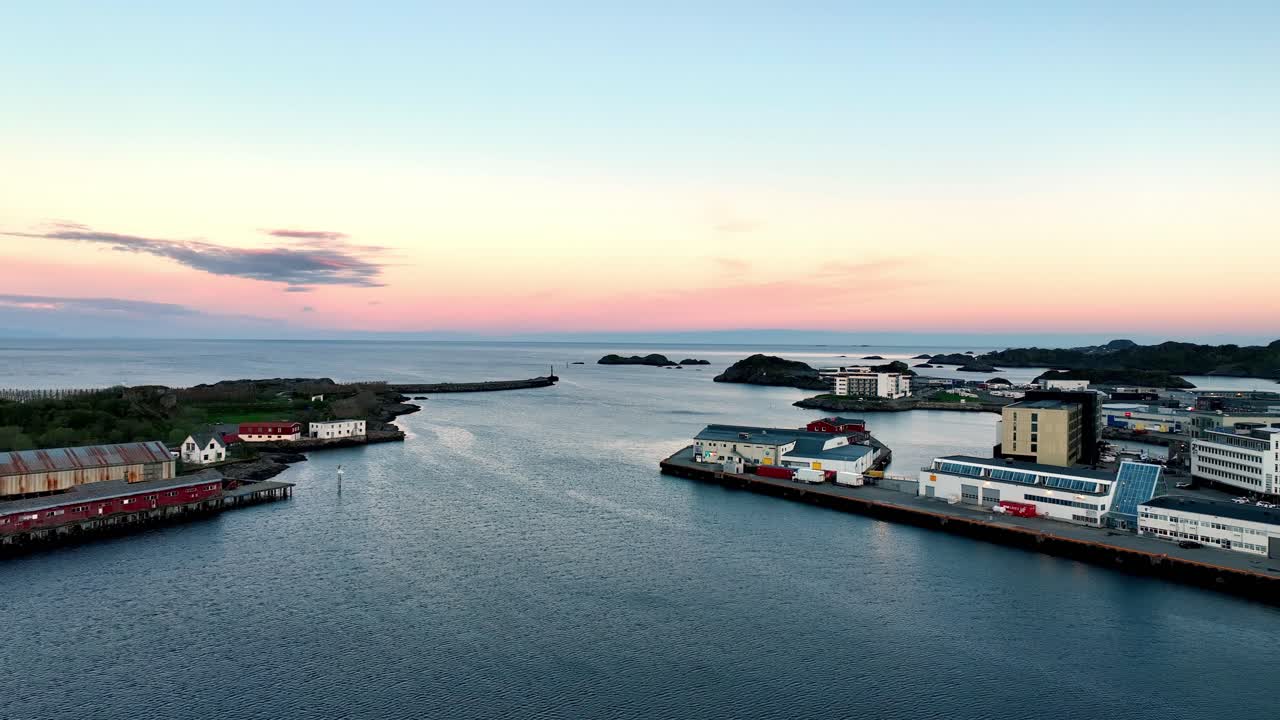 Midnight sun aerial of Svolvaer port with marina, breakwater and glowing horizon over the sea