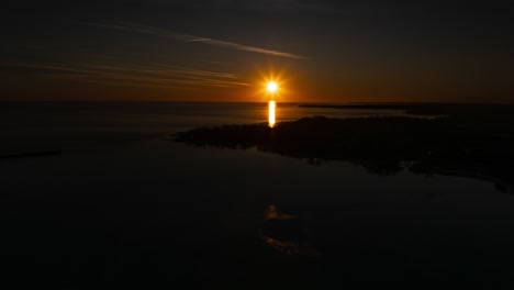 Sunset-over-calm-waters-near-Port-Colbourne-with-vibrant-skies,-timelapse