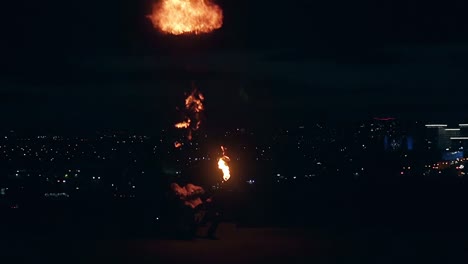 young blond male does tricks with fire male breaths out large stream of fire slow motion shot