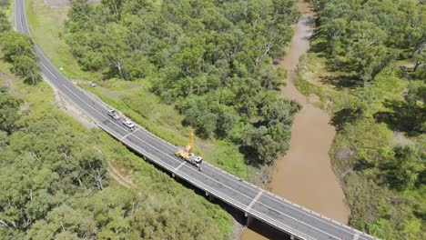 vehicles and construction on a bridge over river