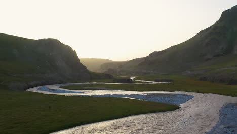 Toma-Aérea-Volando-Sobre-El-Río-Kurumduk-En-Kirguistán,-Hacia-El-Sol