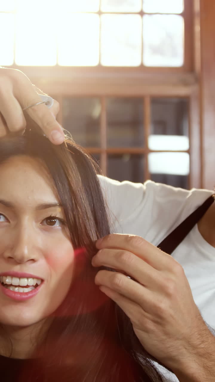 남자 이발사 가 여자 의 머리카락 을 스타일링 하고 있다