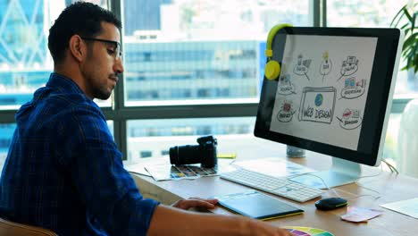 Male-graphic-designer-working-over-graphic-tablet-at-his-desk