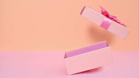 creative romantic pastel pink gift with ribbon opening on bright pink and orange theme. stop motion