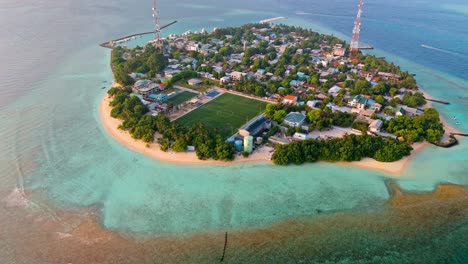 a stunning aerial drone view showcasing rasdhoo island surrounded by crystal-clear turquoise waters and vibrant coral reefs in the maldives.