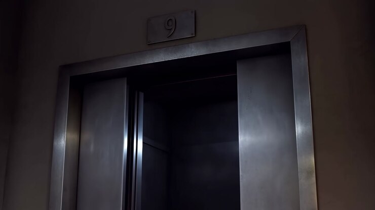 Metal Elevator Doors Opening Dimly Lit Hallway, Ninth Floor Plaque Above Frame, Slow Parting Of Steel Panels