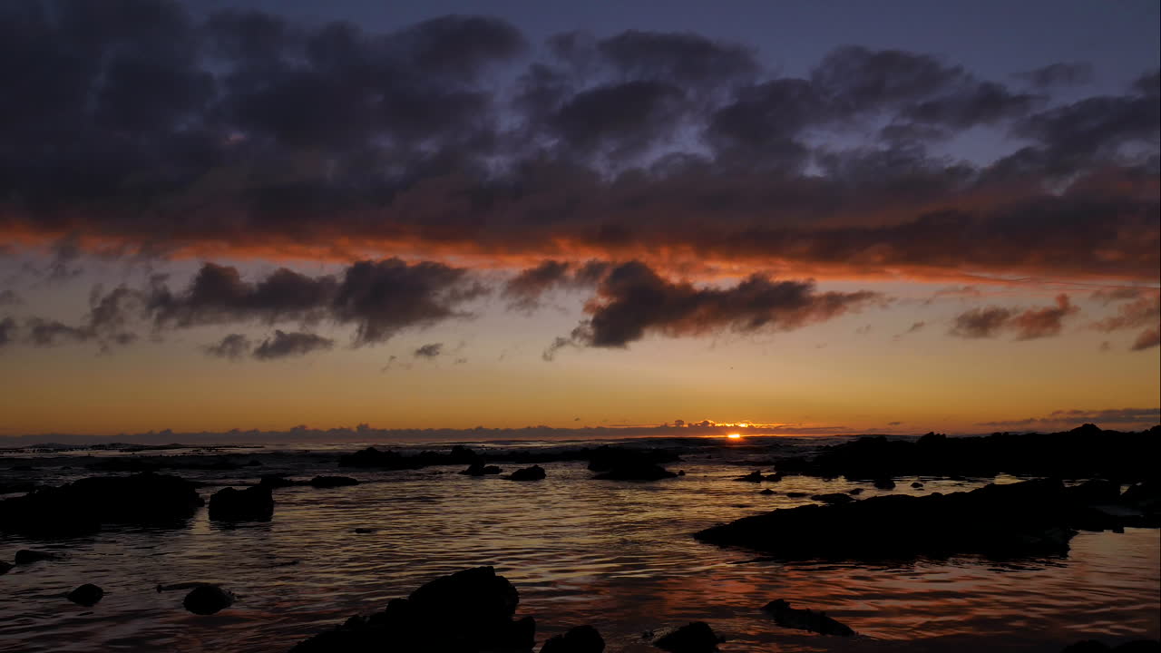 TimeLapse - Lindo pôr do sol dourado com nuvens incandescentes sobre o oceano e movendo-se rapidamente