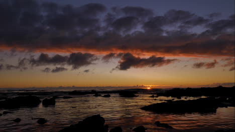 timelapse - beautiful golden sunset with clouds aglow over ocean and moving across quickly