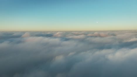 sidewards descent through white puffy clouds - airplane view at sunset